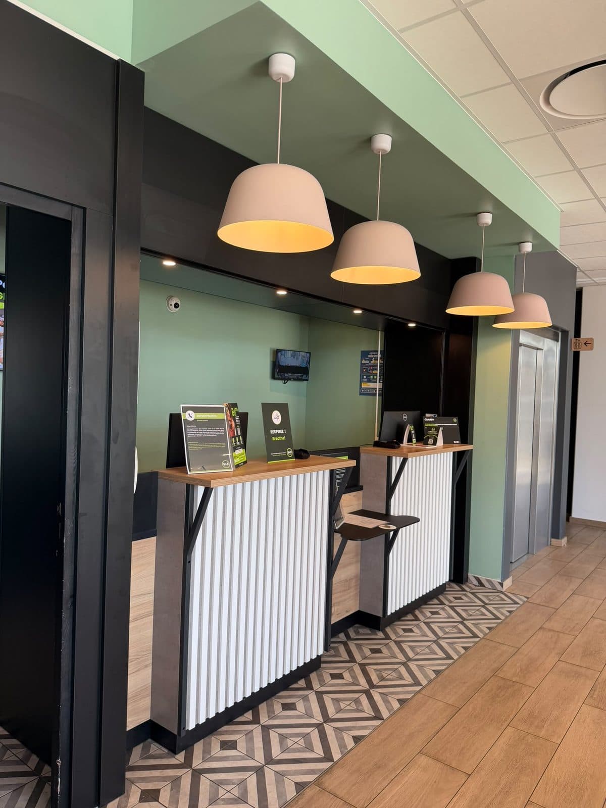 Aménagement intérieur & finitions — Hôtel B&B Hotels — Accueil — murs peints, carrelage effet ciment et comptoir de réception