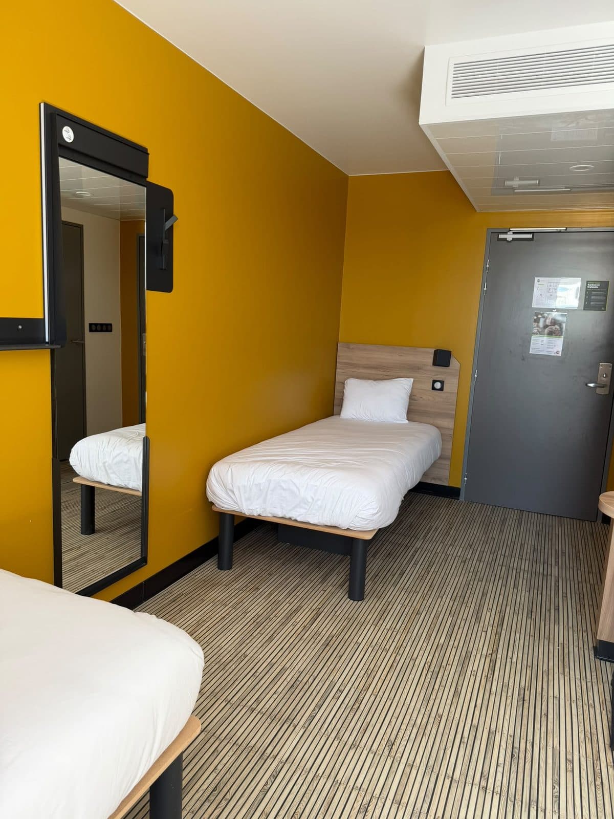 Aménagement intérieur & finitions — Hôtel B&B Hotels — Chambre — mur d'accent ocre et revêtement de sol souple